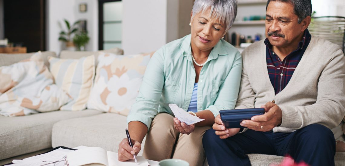 Shot of an elderly couple working out a budget while sitting on the living room sofa.